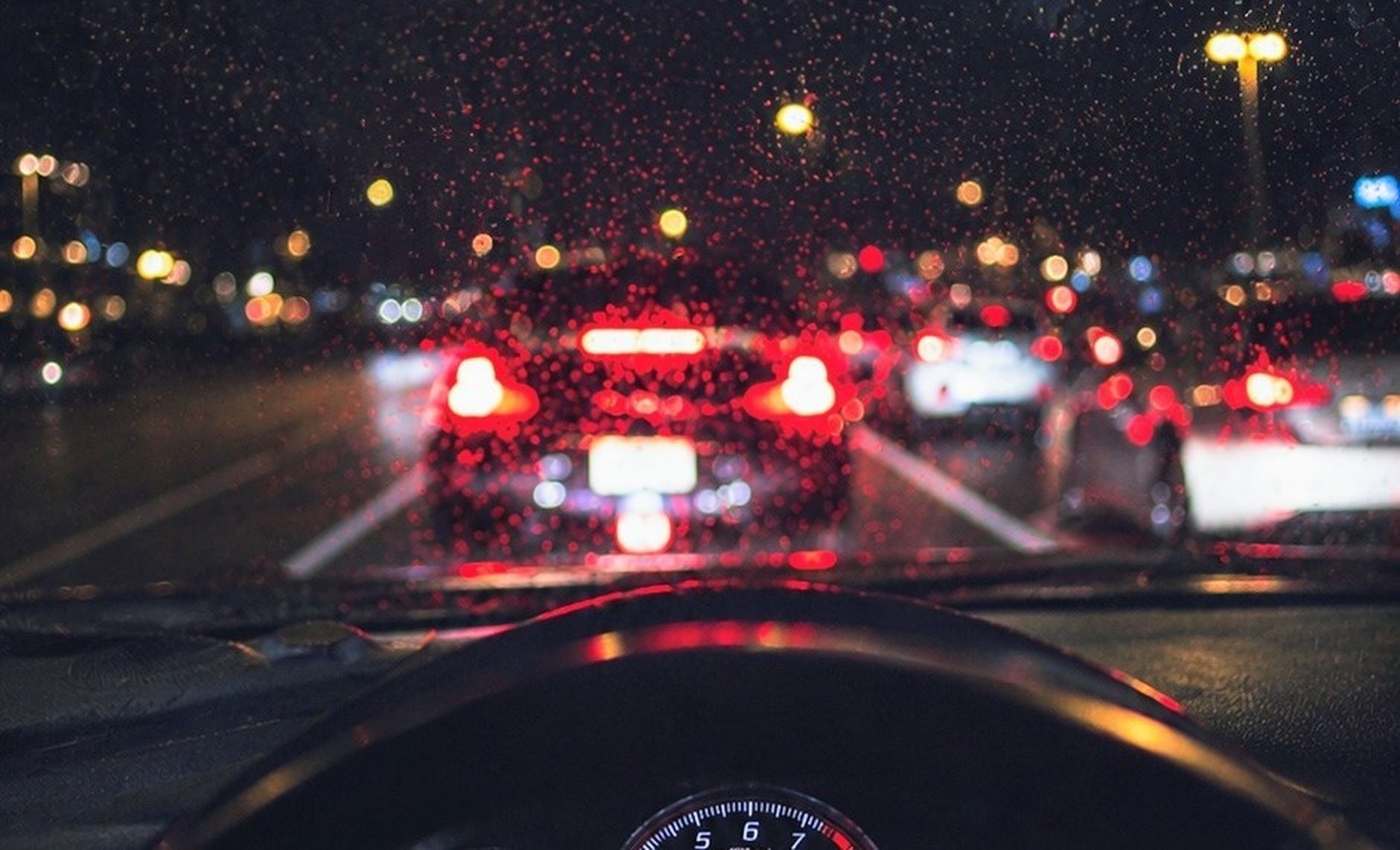 The view through a windscreen at night, wet glass and city lights, the working environment a lesson actually happens in