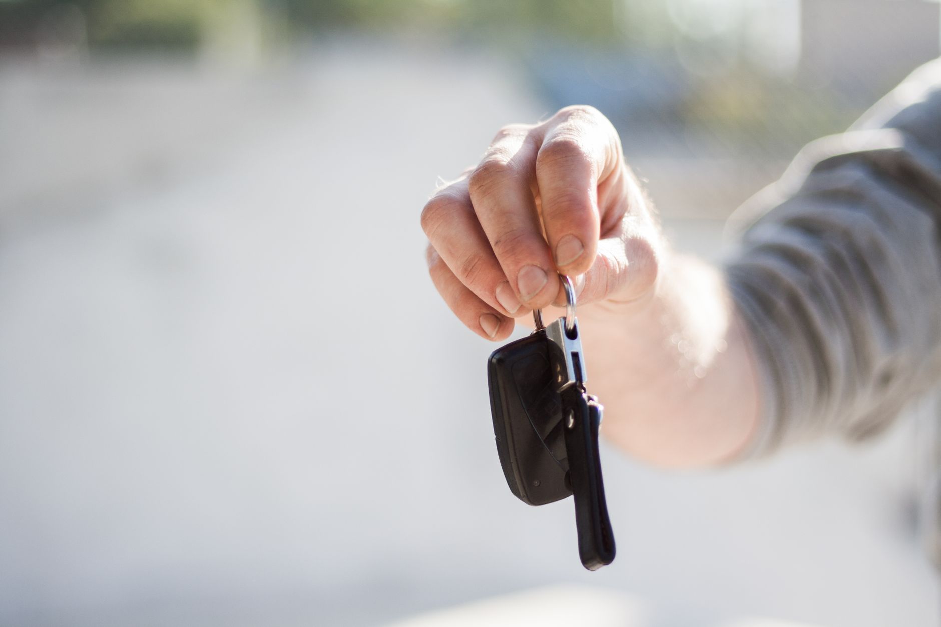 A set of car keys being handed over, the moment a licence finally turns into