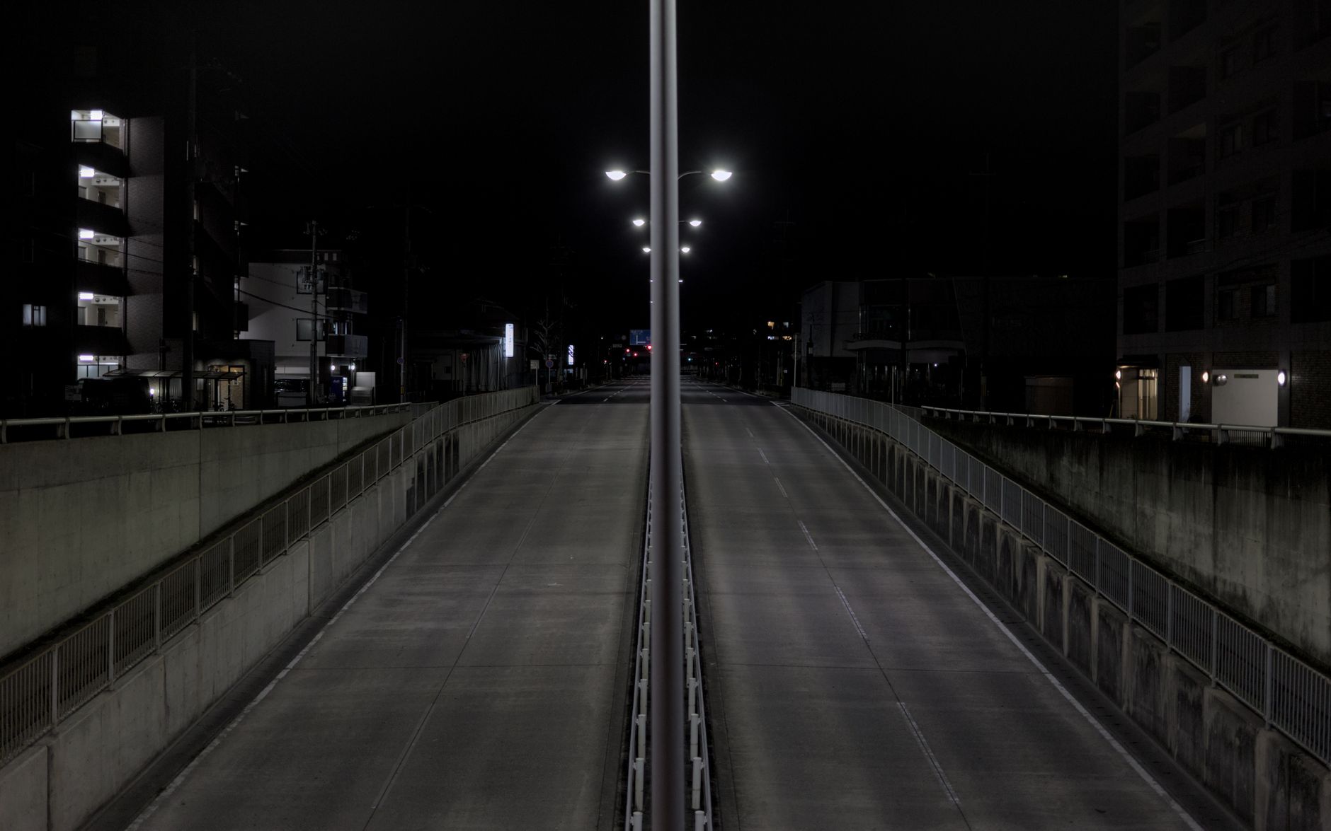 An empty lit motorway stretching into the dark, the kind of long open road that punishes a car you didn't check