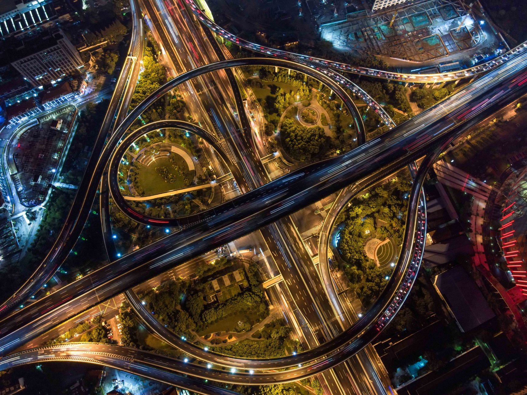 Aerial view of illuminated roundabouts and interchanges at night